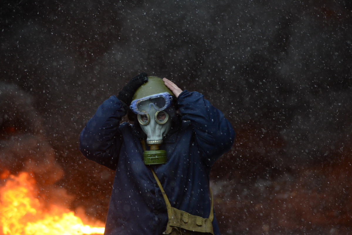 Protester wearing a tear gas mask against background of the mass